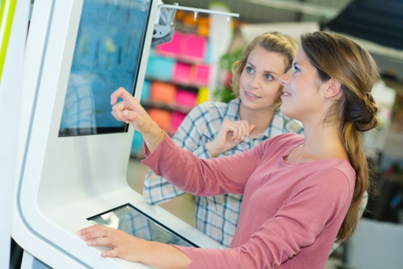 2 Women Using An Interactive Kiosk